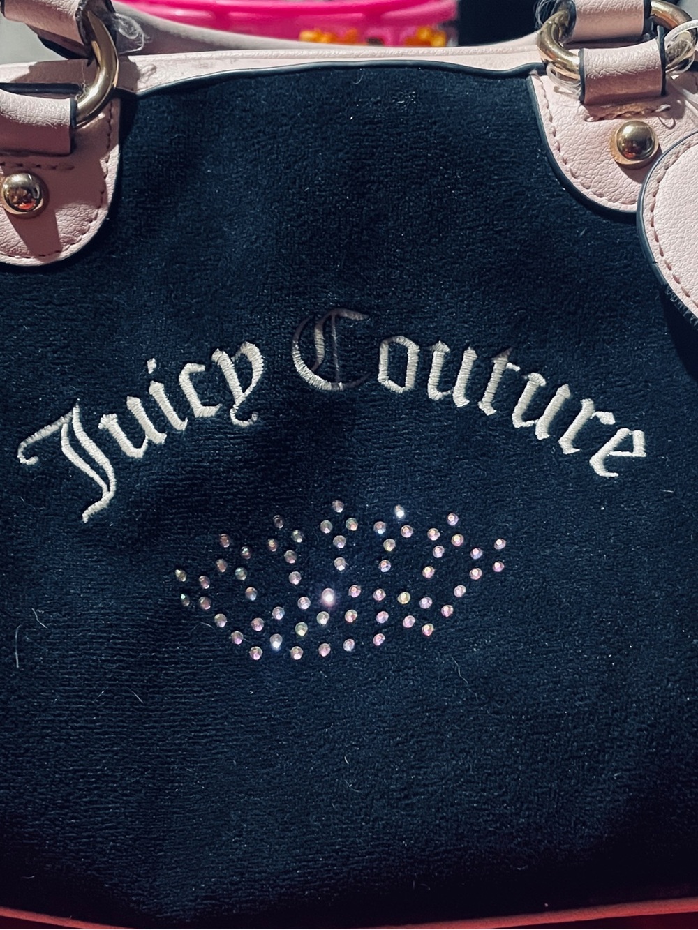 That appears to be a black velour Juicy Couture bowler bag detailed with cream t